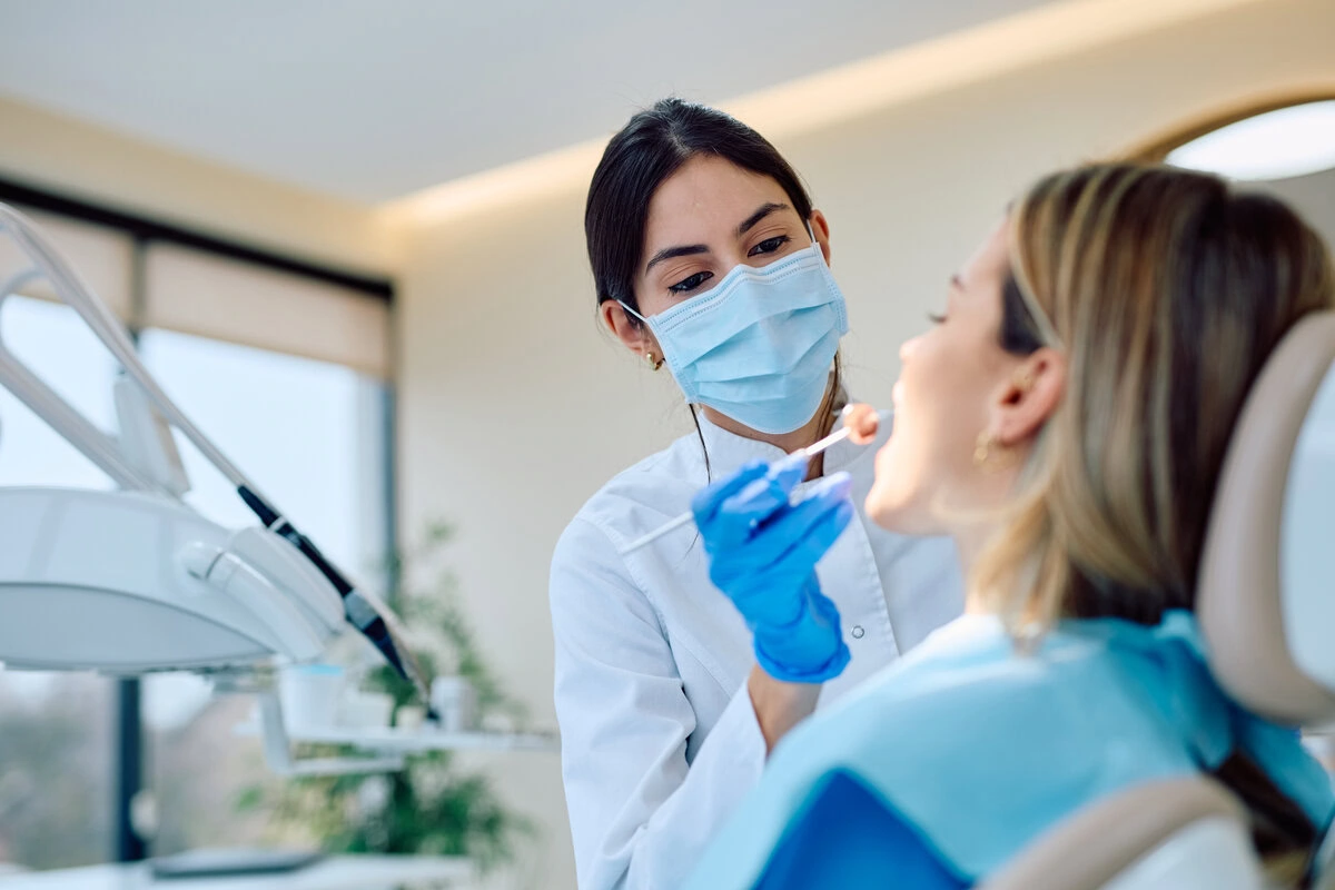 Hygienist cleaning a patient's teeth during a routine visit