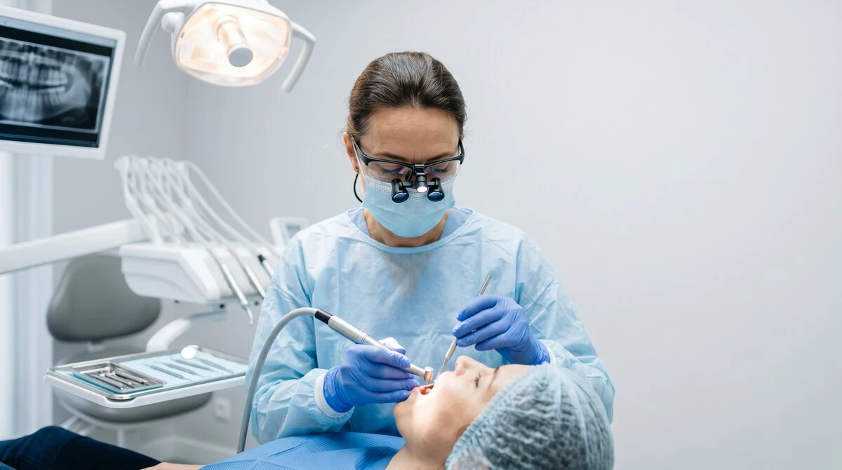 Dentist wearing magnifying loupes while placing a filling