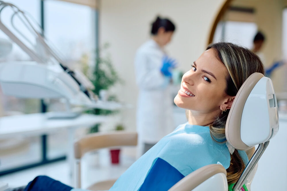 Smiling patient in a dental chair looking over her shoulder