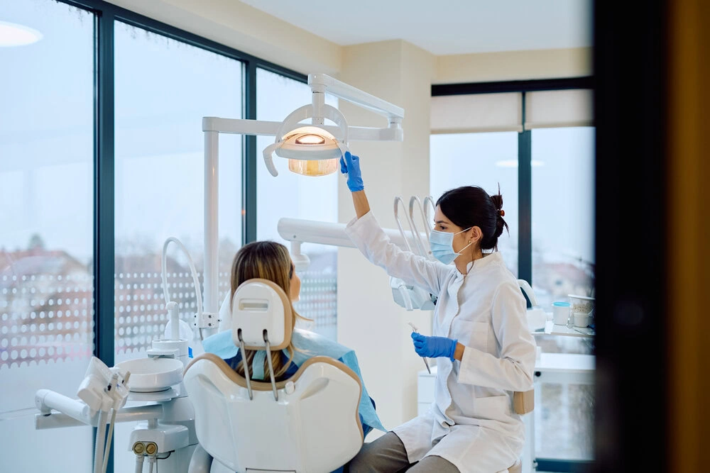Dentist adjusting the overhead light before a patient exam