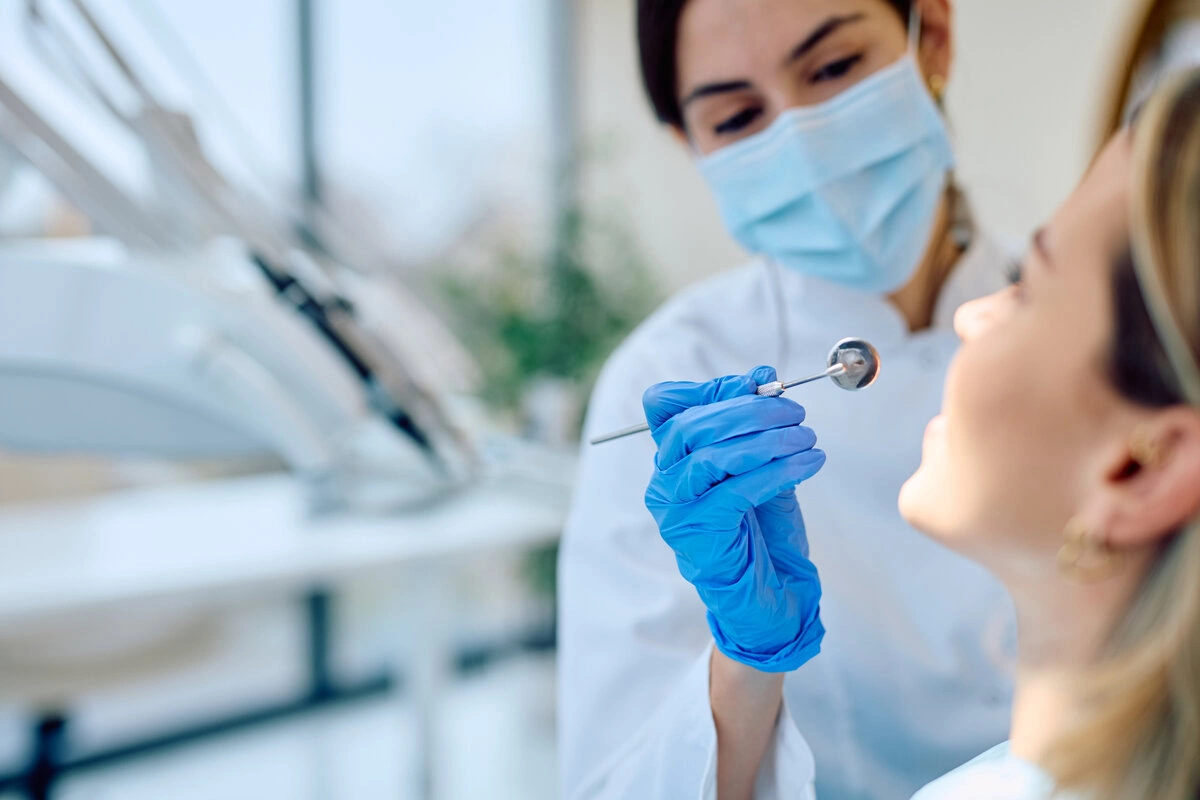 Dentist examining a patient's teeth with dental instruments