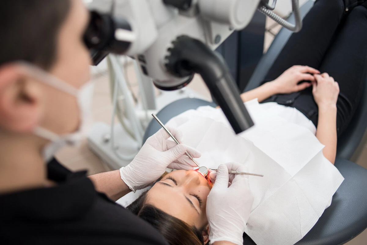 Patient under the overhead light during root canal treatment
