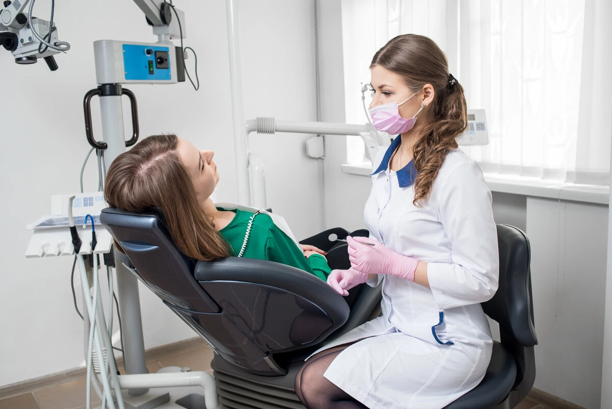 Dentist treating a young patient in the dental chair