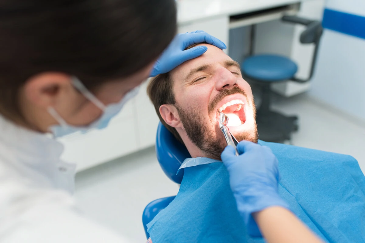 Dentist examining a patient's tooth before an extraction