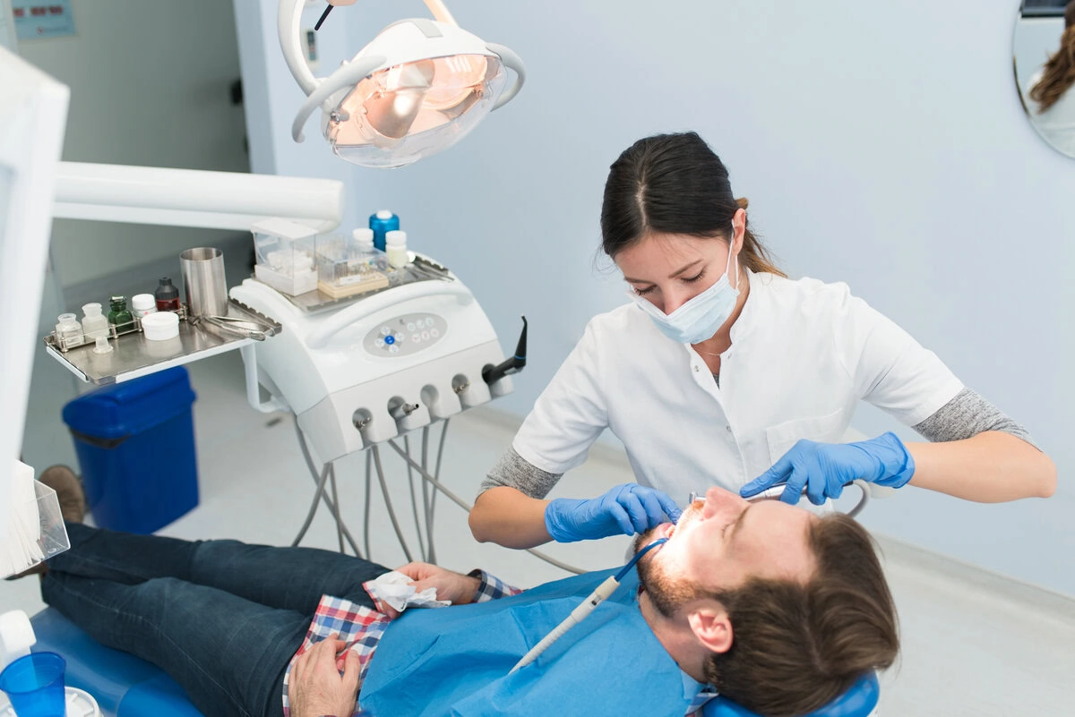 Dental team treating a patient with instrument tray alongside