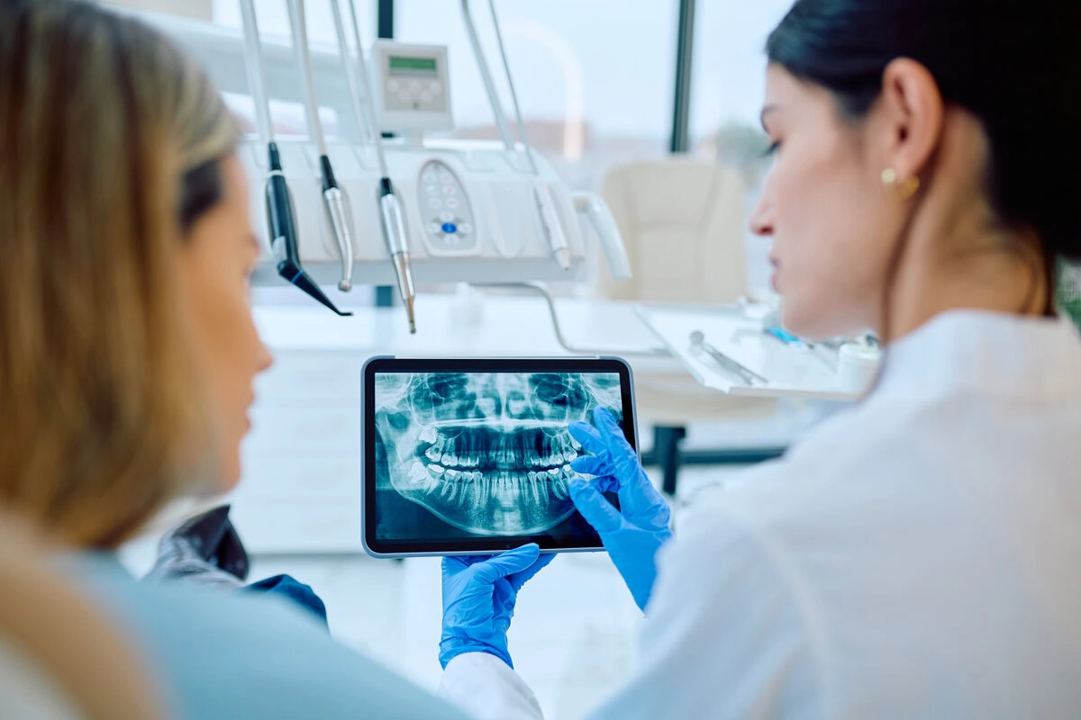 Dentist showing a patient her X-ray images on a tablet